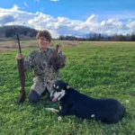 my son Anthony holding up a partridge with his faithfull dog Phoenix by his side